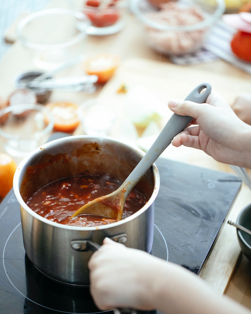 woman stirring a pot of chili