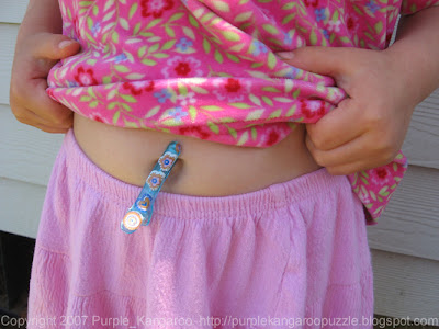 M&M with a barrette clipped to her belly button