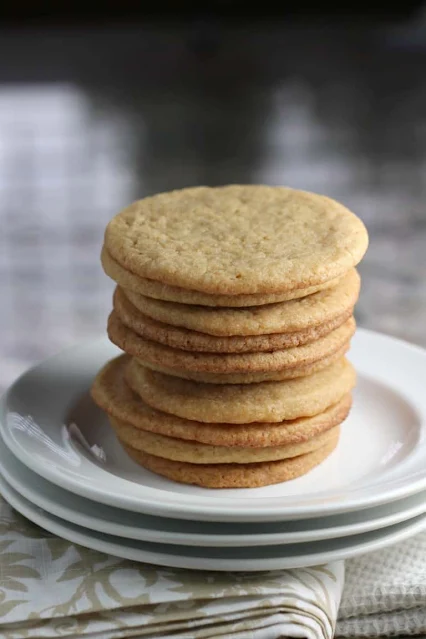 Maple cookies stacked on a plate.