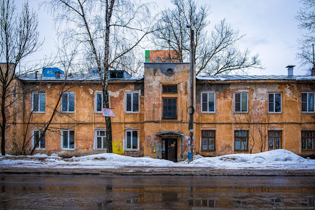 Старое ветхое здание с башенками над подъездами