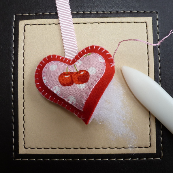 Adding fiber fill into the felt plush ornament while stitching