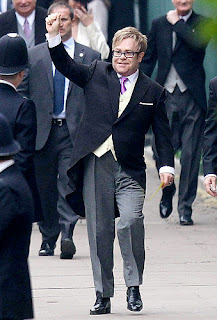 Elton John, a close personal friend of the late Princess Diana, waves as he enters the Abbey