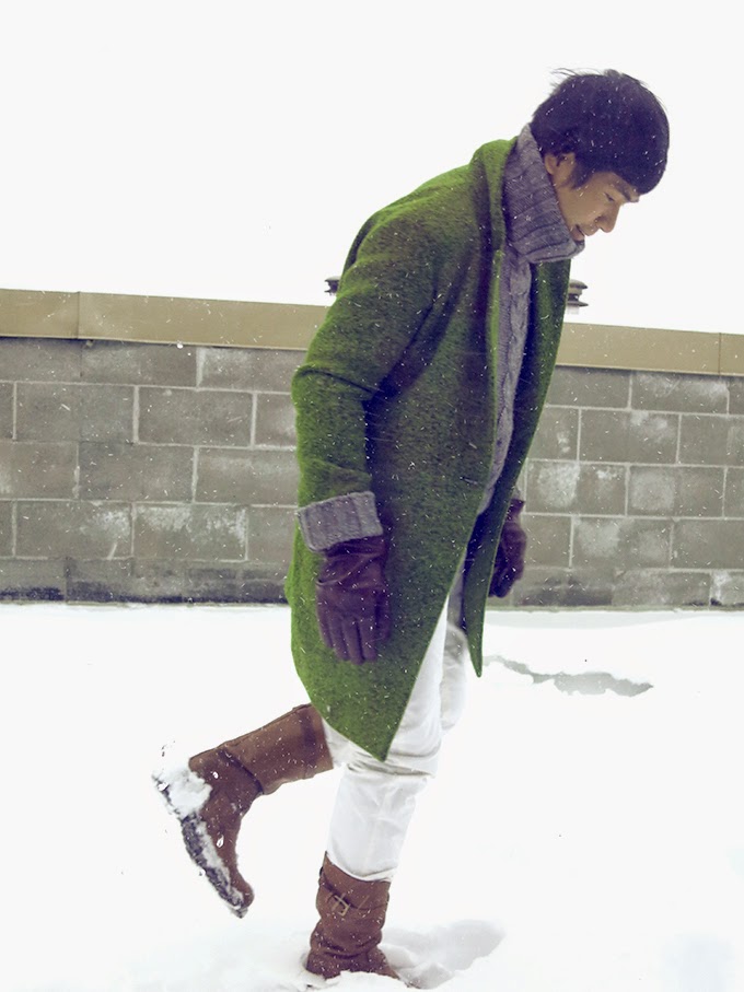 Ben walking in the winter wind and white snow, with Sergio Rossi brown leather boots, wearing unisex apple green wool coat