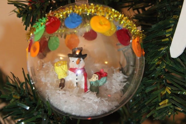 Bola de Natal, transparente, com um boneco de neve e neve artificial dentro, feita à mão