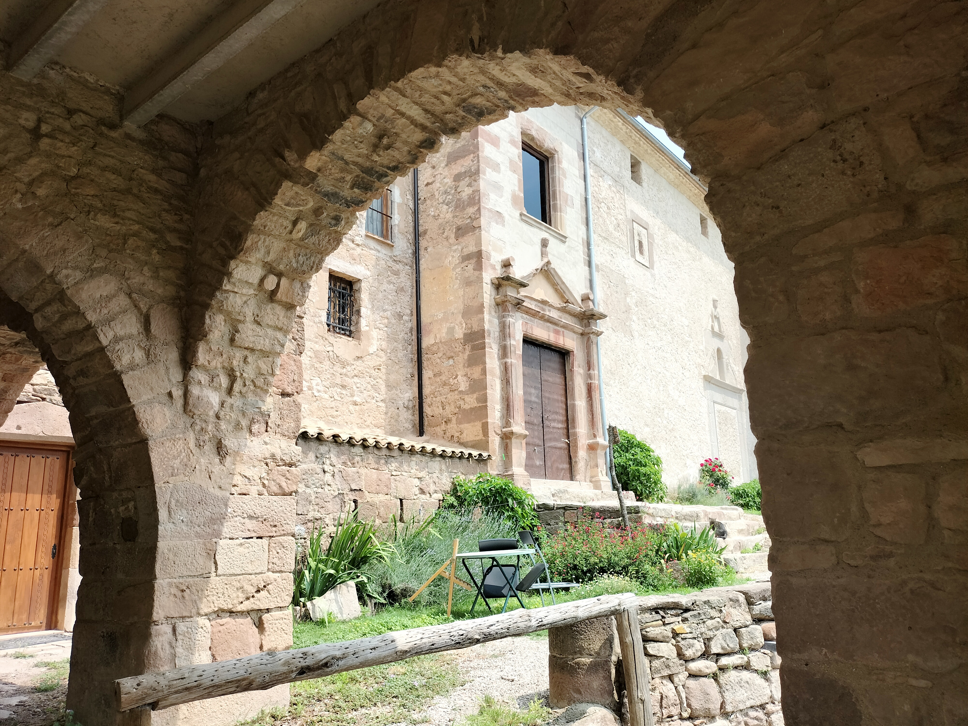 Rectoria de la torre vella de Fals. Arcades i al fons l'església de Sant Vicenç de Fals