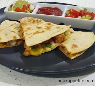 Easy chicken quesadillas packed with onion, garlic and herb, pepper, diced tomato, mozzarella cheese, cheddar cheese and chicken. Chicken Quesadillas Served with tomato sauce and salsa.  Golden brown, crispy chicken quesadillas full of chicken, vegetable and cheese flavor.