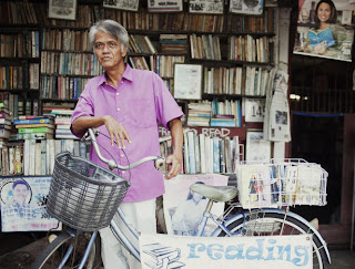 Hernando Guanlao in front of his house/free library