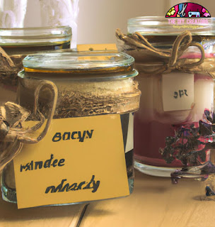Image of homemade candles in glass jars with dried flowers and a handwritten label