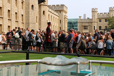 Yeoman Warder giving a tour of the Tower   with the scaffold site in the foreground