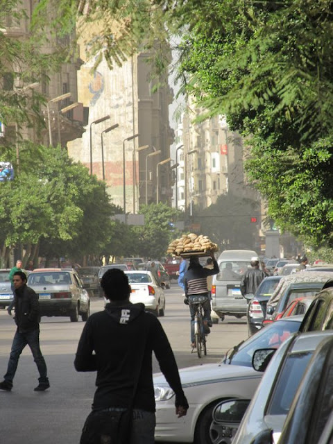 man biking with pita on head, Cairo, Egypt