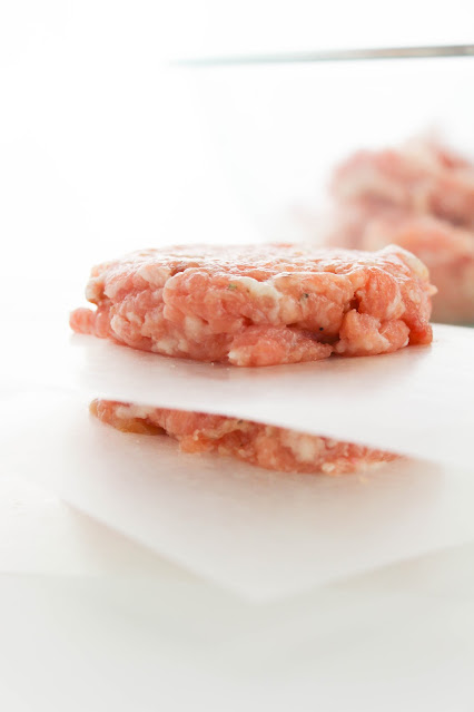 uncooked patties stacked with parchment paper in between.