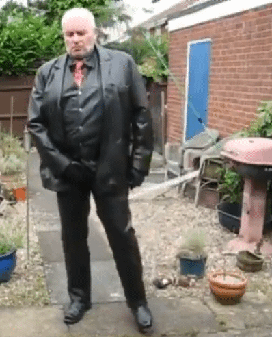 Man in black leather blazer shows off his suit