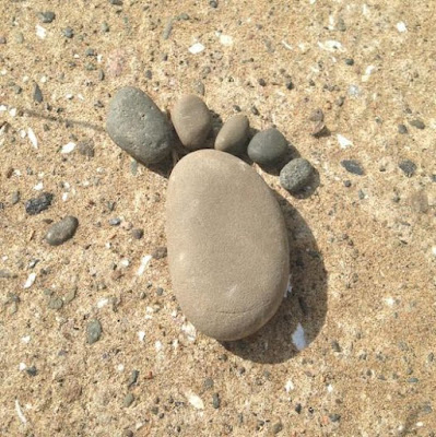 a footprint made of stones, on a stony beach