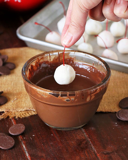 Dipping a Homemade Chocolate Covered Cherry in Chocolate Image