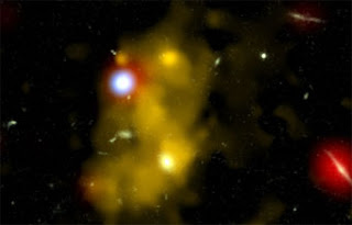 A composite image of a black hole (blue) lighting up a lyman alpha blob (yellow)