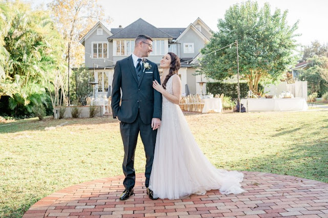 bride holding onto grooms arm in front of The Capen House