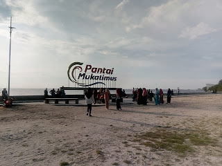 Suasana pantai mukalimus dengan pengunjung yang sedang menikmati suasana pemandangan pantai