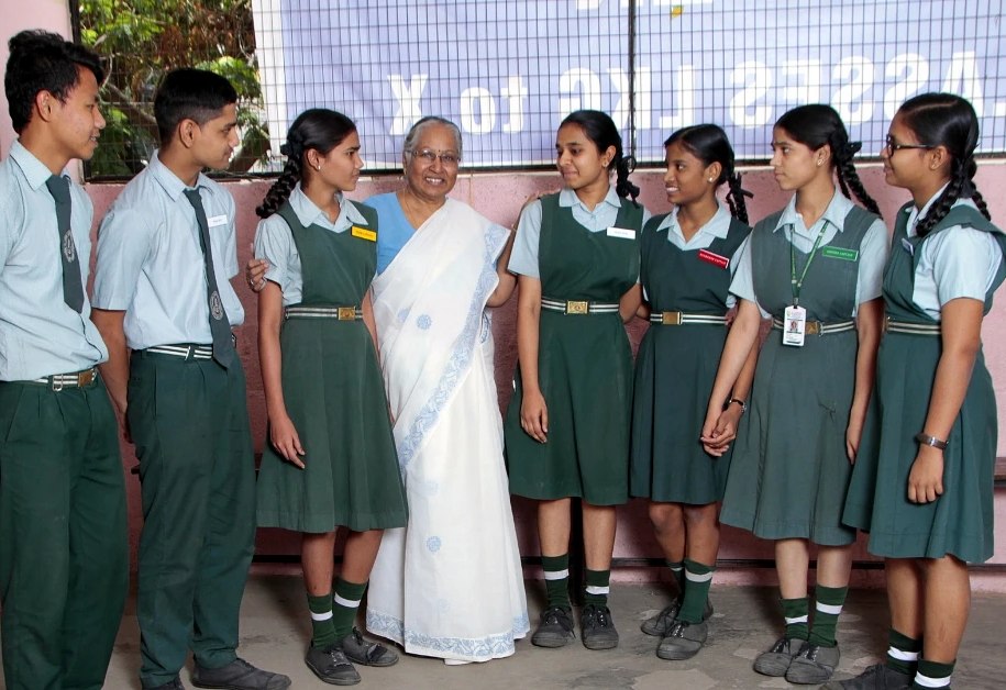 Elderly teacher beside her students