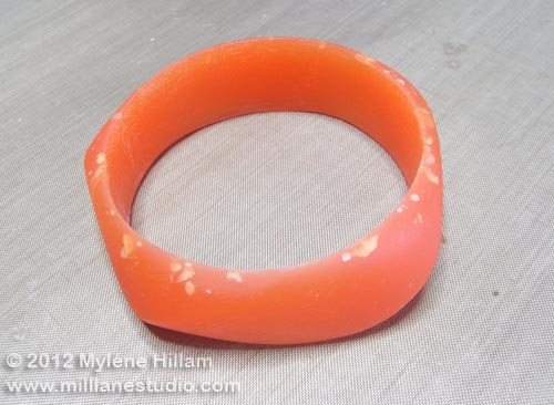 Peach resin bangle with surface imperfections