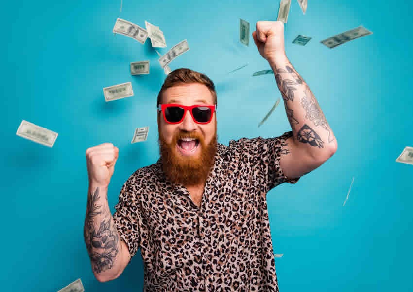 Imagem de fundo azul com um homem barbudo e tatuado de Oculus vermelho sorrindo com os punhos erguidos comemorando e varias notas de dinheiro caindo sobre ele.