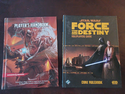 top-down photo of two game books-- the Players Handbook for D&D and the Force and Destiny rulebook for Star Wars