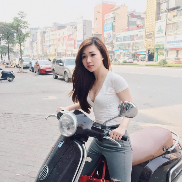 Thiếu nữ áo thun trắng đi xe gắn máy
