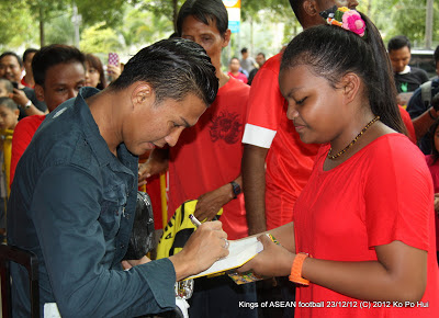 Isa Halim (left) signs for a fan