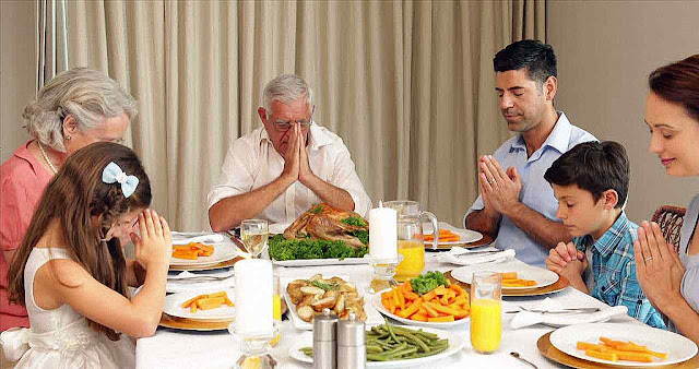 Família francesa rezando na mesa