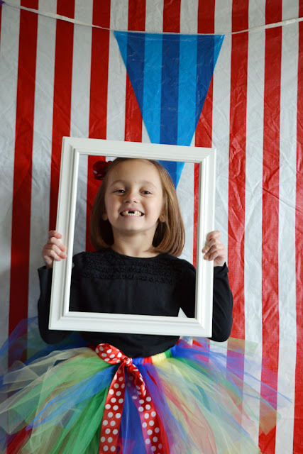 girl using frame in photobooth, tulle skirt, pennant banner