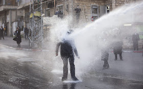 In this Wednesday, March 15, 2017 file photo, an ultra-Orthodox Jew gets hit by a police water canon during a protest against Israeli army conscription in Jerusalem. (AP/Oded Balilty)