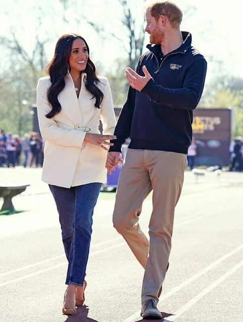 Meghan Markle wore a white belted jacket from Brandon Maxwell Fall-2022 collection. Prince Harry met athletes and organisers