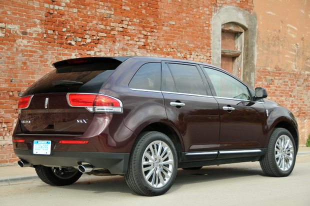 Rear 3/4 view of dark red 2011 Lincoln MKX parked in front of brick building