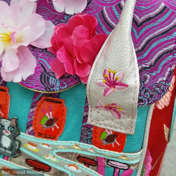 close up of floral embroidery on short handle of bag