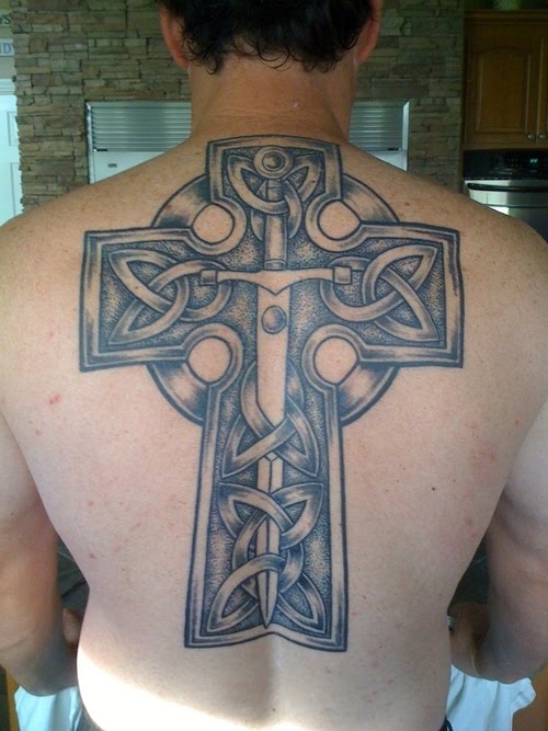 Cross with sword on back tattoo.