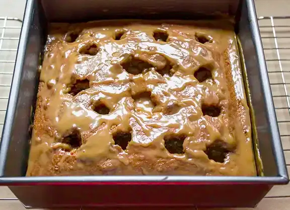 Poke cake ready to top with caramel.