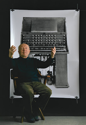 Oskar Sala ante una fotografía del Mixturtrautonium, un instrumento electrónico único originalmente desarrollado por Friedrich Trautwein