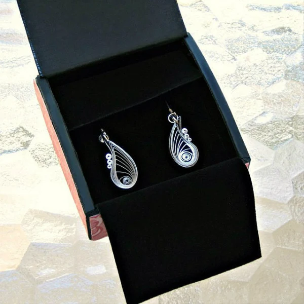 Quilled pair of silver and black teardrop earrings in a patterned paper covered jewelry box with black lining