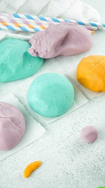 playdough balls lined up on paper squares.