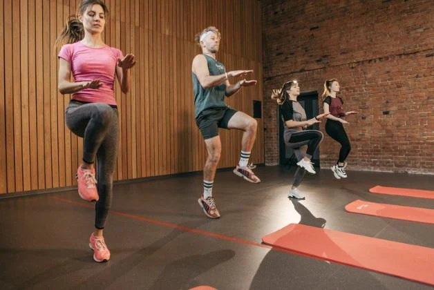 Man and three women performing High Knee March as part of low impact HIIT exercises