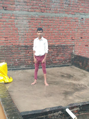 A country boy from India standing on the terrace after the rain and smiling