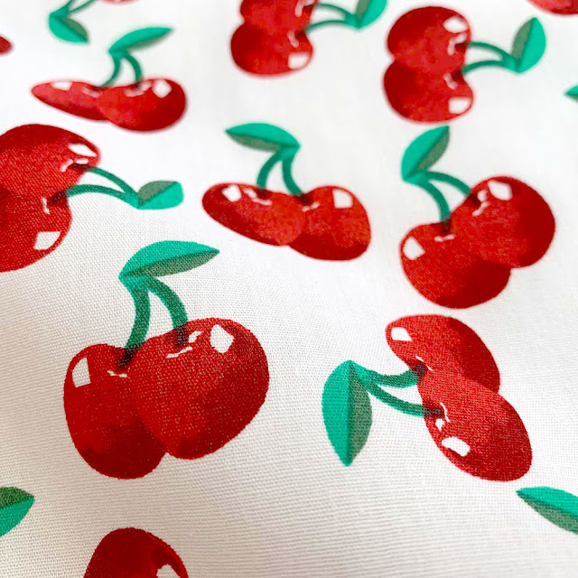 metervarer med kirsebær print - hvidt stof med kirsebær naturtro farver: røde/grønne farver