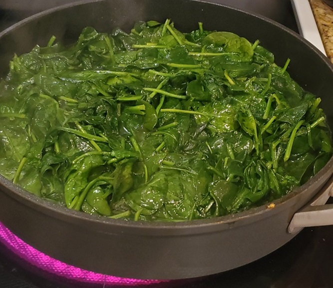 a large frying pan full of sauteed spinach
