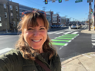 A selfie of me, smiling huge, with the newly-protected intersection of 5th and Washington behind me.