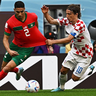 Defender Achraf Hakimi of Morocco fights for the ball with midfielder Luka Modric of Croatia during the FIFA World Cup 2022 match at the Al Bayt Stadium in Qatar