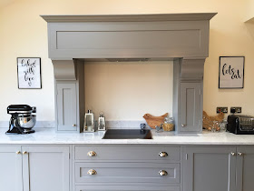 bespoke open plan kitchen diner with bifold doors, Carrara marble and solid oak worktops, farrow and ball Manor House grey and downpipe units, island, integrated appliances, pendant lighting and statement extractor hob. shaker style kitchen inspiration.