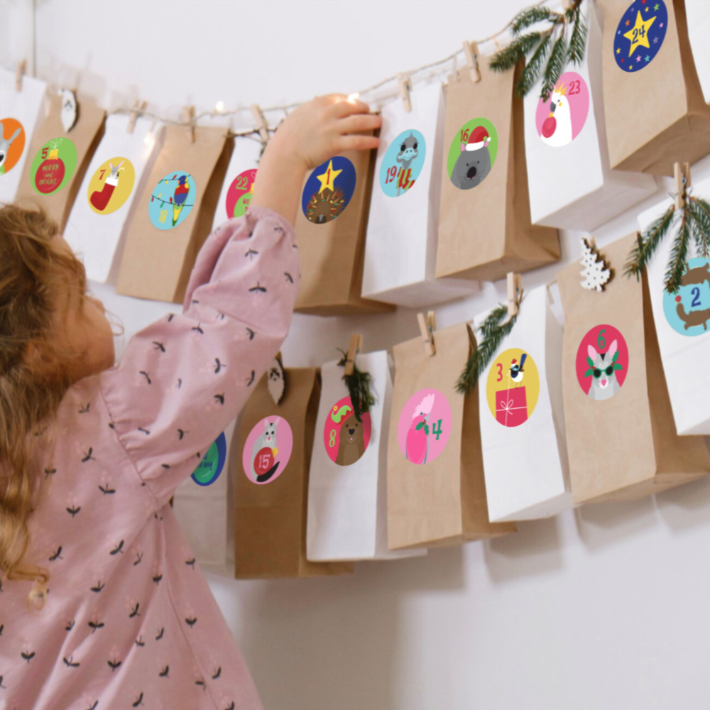 child opening paper bag advent calendar decorated with colourful Australian animals