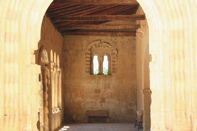 wnętrze portyku romańskiego kościoła w Sotosalbos, na wprost bliźniacze okno, biforium, przedzielone kolumną o rzeźbionych kapitelach