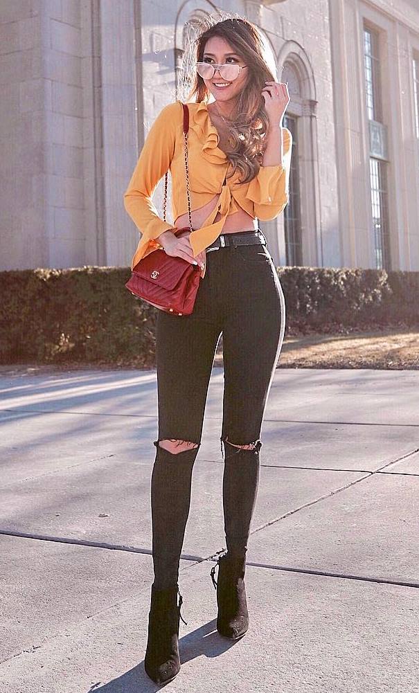 amazing outfit idea / boots + black rips + bag + yellow ruffle top