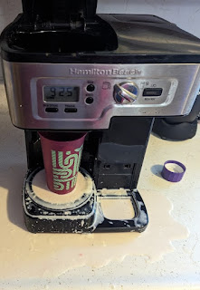 overflowing cup of milk sitting in coffee maker