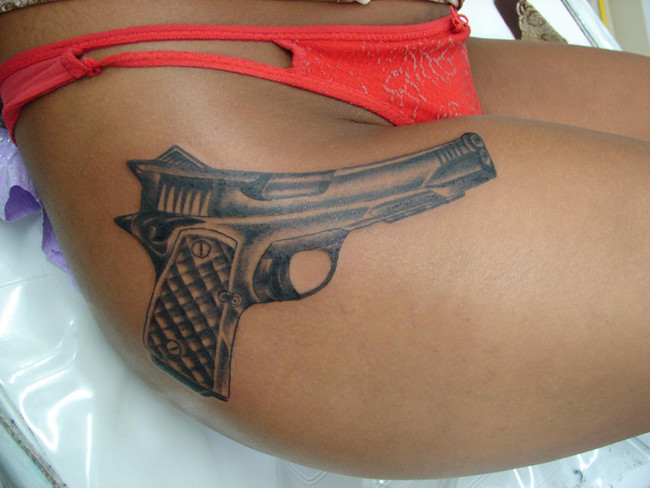 pistol tattoos. Modern pistol on lower hip
